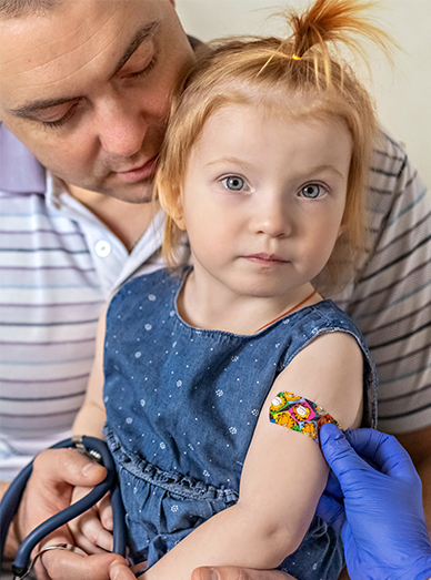 Toddler receiving a vaccination on the upper arm while a parent supports them at Mittagong Doctors.