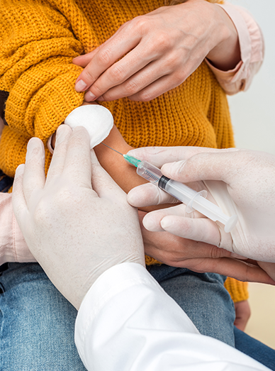Close-up of a clinician preparing and giving a flu shot to a patient’s arm at Mittagong Doctors.