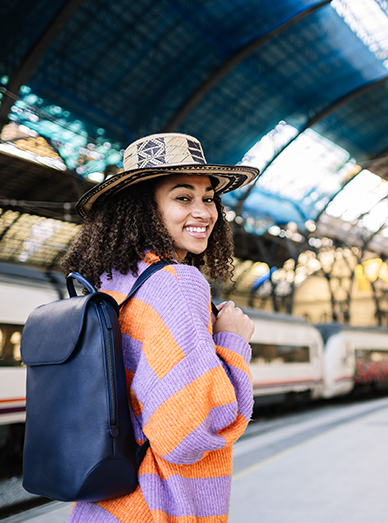 Smiling traveler with backpack standing on a train platform before a journey at Mittagong Doctors.